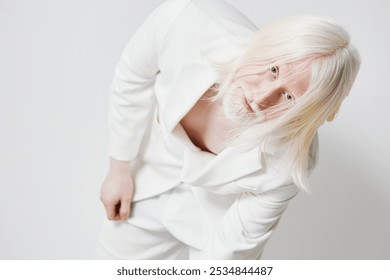 Artistic portrait of an androgynous model with long white hair in a white suit against a minimalistic light background, conveying a sense of elegance and modernity - Powered by Shutterstock