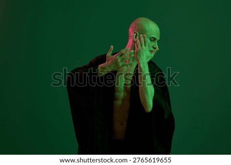 Artistic representation of a man posing dramatically, showcasing strength and emotion with a green light background for a striking contrast.
