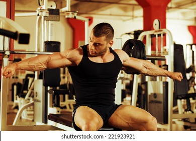 artistic shot, golden retouch, of a young bodybuilder hard training in the gym: tensing muscles on the bench press
