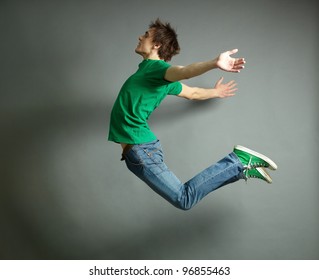 Artistic shot of a guy jumping high and posing meanwhile