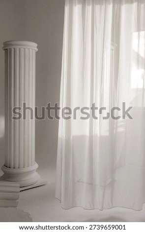 An artistic studio setup featuring white fluted architectural columns, including a fallen pillar on the floor, creating a 