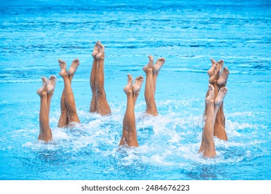 Artistic swimming team in swimming pool performing synchronized legs movement - Powered by Shutterstock