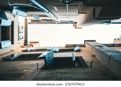 An artistic, vertical low-angle perspective looking straight up from a narrow passage or courtyard in Venice. The composition is framed by tall, aged buildings with characteristic dark green wooden shutters, some open and some closed. The weathered plaster and stone walls contrast with the stark, bright white sky at the center. Visible details like drainage pipes and industrial beams add an 