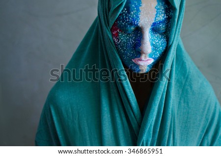 artistically painted woman in green mantle