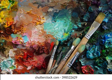 artists brushes and oil paints on wooden palette. Vintage stylized photo of paintbrushes closeup and artist palette. palette with paintbrush and palette-knife