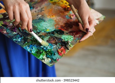 artists brushes and oil paints on wooden palette. macro artist's palette, texture mixed oil paints in different colors and saturation. palette with paintbrush and palette-knife hands.  - Powered by Shutterstock