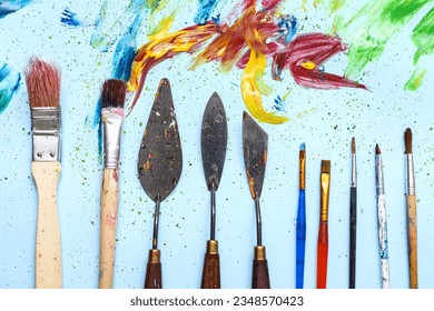 Artist's brushes  palette knives   paints blue background