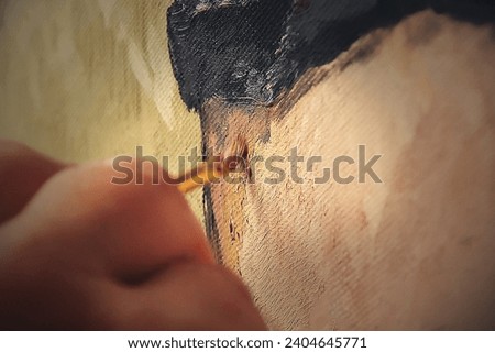 An artist's hand meticulously adding detail to a painting, with a focus on the texture of the canvas and the stroke of the brush