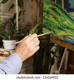 Artist's Hand With Paintbrush At Painting Process