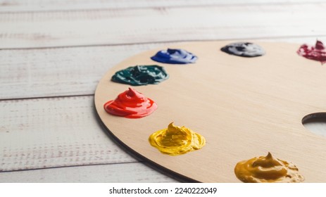 Artist's palette with samples of colorful paints on white wooden table, closeup. Space for text - Powered by Shutterstock