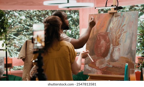 Artists recording creative process of painting an artwork piece, hosting online art class for instruction and remote learning. Diverse painters showing supplies and paint tubes used. Camera A. - Powered by Shutterstock