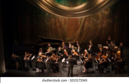 Artists symphony orchestra. abstract blurred image. Musician plays a musical instrument on the concert stage. Background for design, blur texture, actors on stage scene in concert.
