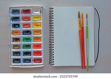 Artist's workplace. Art supplies brushes, watercolor paints, sketchbook. Art studio. Drawing lessons. Creative workshop. Design place. - Powered by Shutterstock