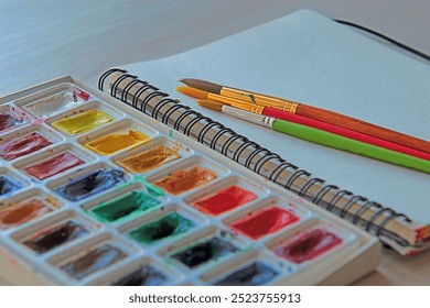 Artist's workplace. Art supplies brushes, watercolor paints, sketchbook. Art studio. Drawing lessons. Creative workshop. Design place. - Powered by Shutterstock