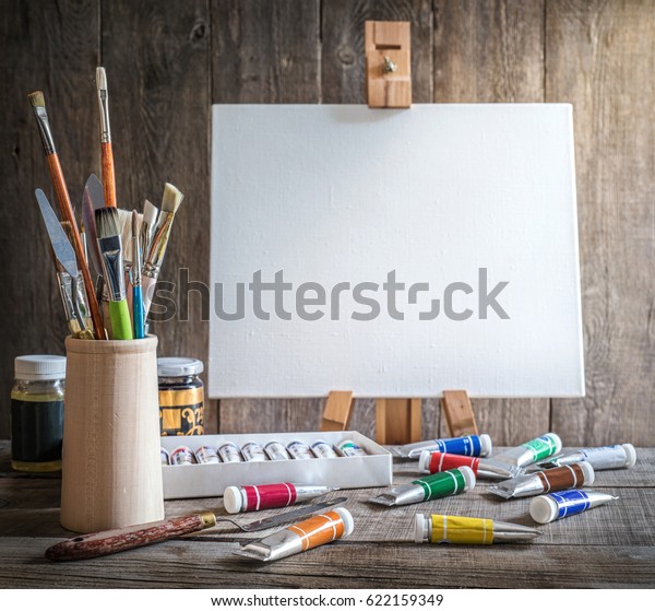 Artist\'s workshop. Canvas, paint, brushes, palette\
knife lying on the\
table.