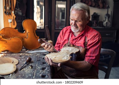 Arts and crafts. Senior carpenter craftsman carving wood in his old-fashion workshop. An experienced caucasian elderly man manually making masterpiece. Handcraft and creativity. - Shutterstock ID 1802209609