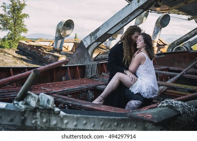 Artsy Picture Of A Couple Embracing In A Wooden Boat.