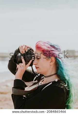Artsy woman taking a photo at a beach