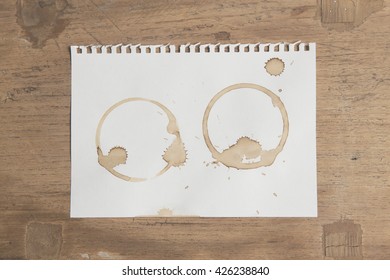 Artwork Coffee Ring Stains On White Paper On Grunge Wooden Table Background