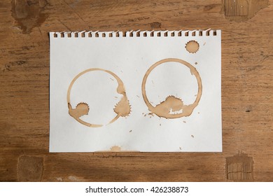 Artwork Coffee Ring Stains On White Paper On Grunge Wooden Table Background