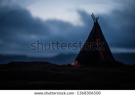 Artwork decoration creative concept. An old native american teepee in desert at the evening. Wigwam house indian style.