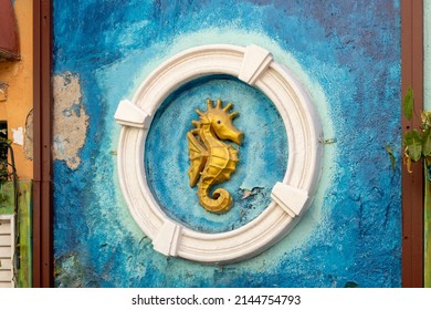 Artwork Of A Golden Sea Horse In A White Circle On The Wall Behind The Tables And Bar Stools Of A Cozy Bar In Willemstad, Curacao