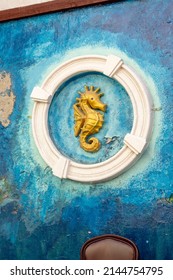 Artwork Of A Golden Sea Horse In A White Circle On The Wall Behind The Tables And Bar Stools Of A Cozy Bar In Willemstad, Curacao