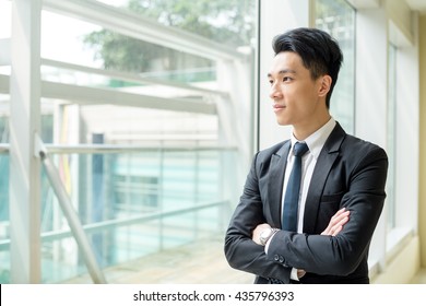 Asain Businessman Looking Out Of Window