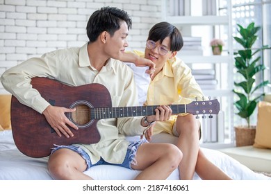 Asain Gay Couple Playing Guitar Together In Home, LGBTQ Concept.