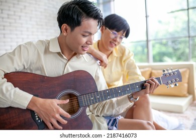 Asain Gay Couple Playing Guitar Together In Home, LGBTQ Concept.