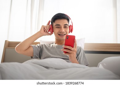 Asain Guy Enjoy The Music On His Bed