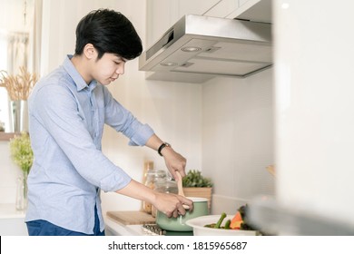 Asain Man Cooking In The Home Kitchen.