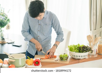 Asain Man Cooking In The Home Kitchen.