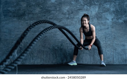 Asain Woman with battle rope battle ropes exercise in the fitness gym. gym, sport, rope, training, athlete, workout, exercises concept - Powered by Shutterstock