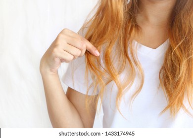 Asain Woman Holding Her Long Hairs That Make Color Treatments. The Hairs Maybe Have Problem Breakage (split End) .Should Care Or Cut End Of Hairs. On White Background.