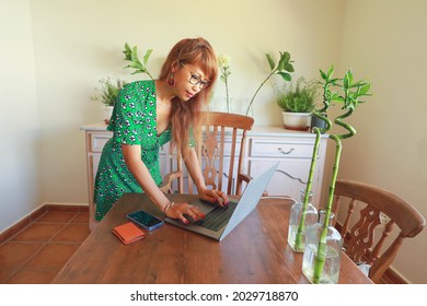 Asain Woman Wearing Green Dress Working On Lap Top In The Office