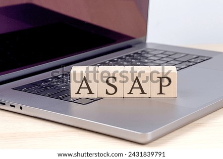 ASAP word on a wooden block on laptop, business concept