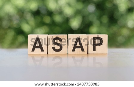 ASAP - word written on wooden blocks. The text is written in black letters and is reflected in the mirror surface of the table. Business concept for your design.