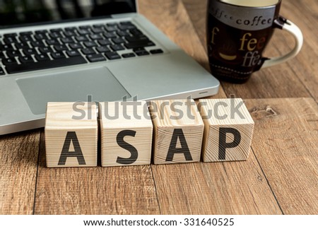 ASAP written on a wooden cube in front of a laptop