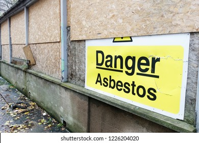 Asbestos danger sign at building construction site refurbishment of old building