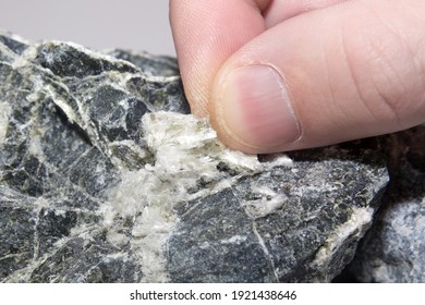 Asbestos mineral fiber in human fingers, close-up.