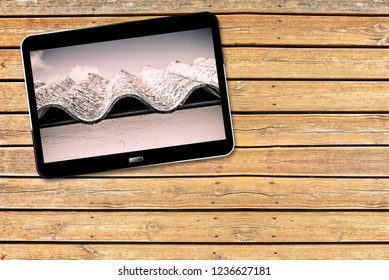 Asbestos roof: one of the most dangerous materials in the construction industry - Concept with 3D render of a digital tablet on wooden background 