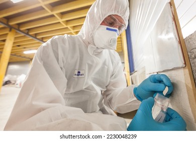 Asbestos surveyor taking a sample of building material, detection of asbestos, in accordance with the recommendations of standard NF X 46-020