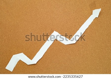ascending graph made from paper strips on a cork board