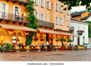 Ascona, Switzerland - August 23, 2016: People In Street Cafe At Romantic Luxury Resort In Ascona Town On Lake Maggiore, Ticino Canton In Switzerland. Outdoor Expensive Family Restaurants In Swiss City