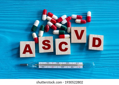 ASCVD (Atherosclerotic Cardiovascular Disease) - Acronym On Wooden Cubes On A Blue Background With Tablets And Thermometer. Medical Concept