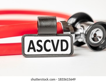 ASCVD Atherosclerotic Cardiovascular Disease Lettering On A Business Card With A Holder, Next To The Red Stethoscope. Medical Concept. Treatment And Prevention. Human Health.