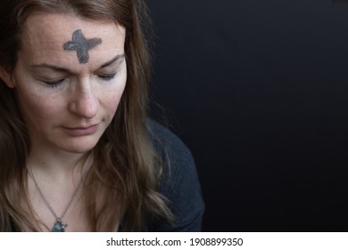 Ash cross on woman's forehead - Shutterstock ID 1908899350