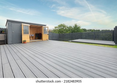 Ash grey composite decking built on two levels on a residential back garden with low voltage deck lights installed as well. Good Image for a landscape Gardiner - Shutterstock ID 2182483905