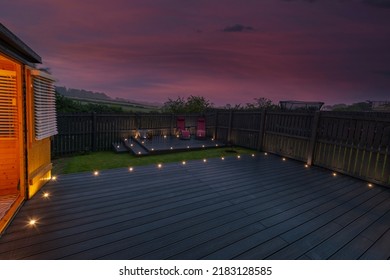 Ash grey composite decking built on two levels on a residential back garden with low voltage deck lights installed as well. Good Image for a landscape Gardiner - Shutterstock ID 2183128585